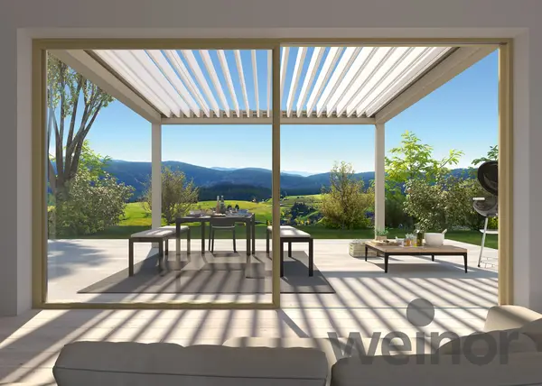 Lamellendach Pergola auf Terrasse mit Esstisch und Blick ins Grüne